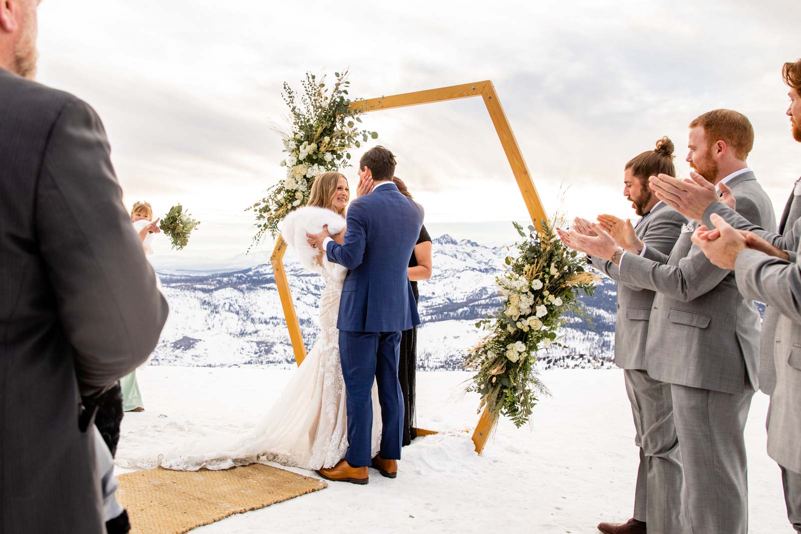 Bride holds groom's face during ceremony on Mammoth Mountain