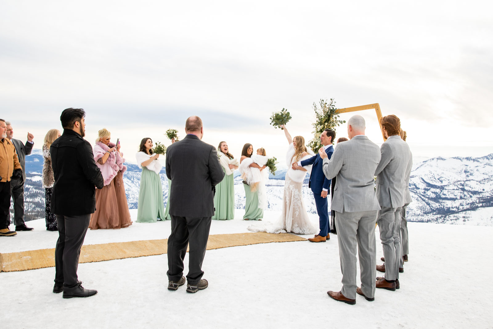 Bride holds holds up bouquet end of ceremony on Mammoth Mountain