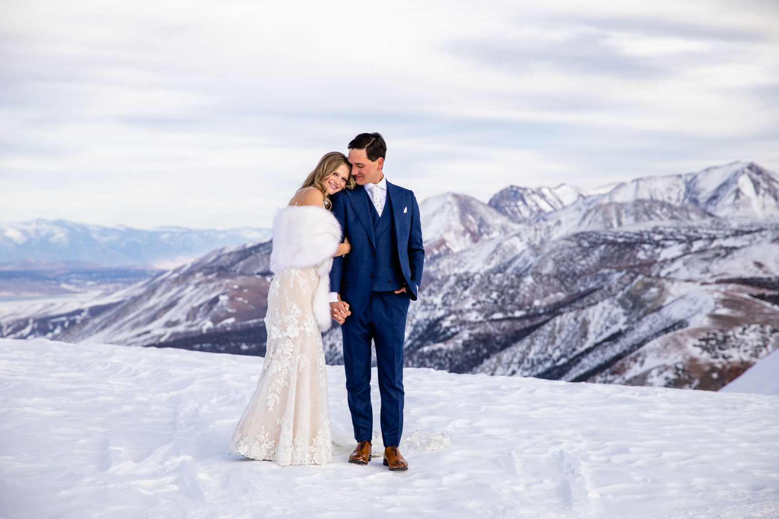 Bride and groom smile on Mammoth Mountain with the Eastern Sierra mountains