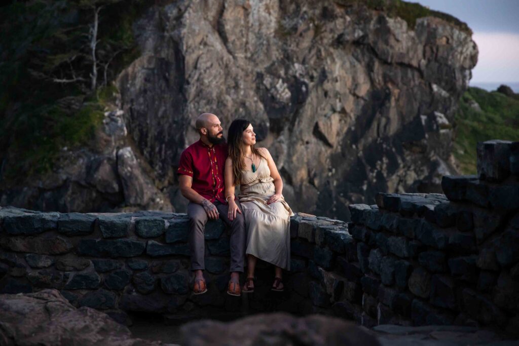 engaged couple on wedding rock embrace  agate beach engagement 